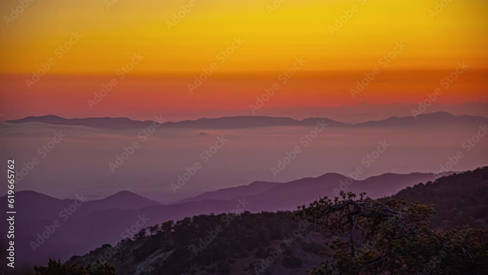 Golden sunset over a hazy mountain range as seen from Mount Olympos, Cyprus - time lapse Golden sunset over a hazy mountain range as seen from Mount Olympos, Cyprus - time lapse