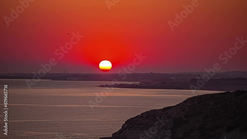 Golden sunset time lapse as seen from the rocky shoreline near Kouklia, Cyprus photo