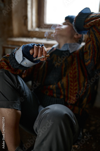 Girl in old dirty, ragged clothes smoking cigarette, selective focus