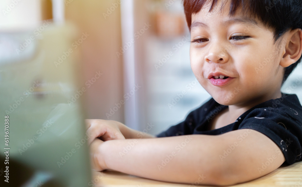 Happy cute little Asian sitting, relaxing and having fun with mobile phone or playing games Happy cute little Asian sitting, relaxing and having fun with mobile phone or playing games