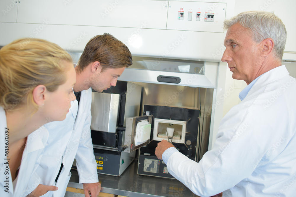 Obraz premium Man removing object with tongs, students watching