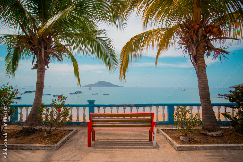 Tropical dreams, picturesque palms surrounding a red bench with a view towards an islands and a beach with boats. Beautiful destination photo, travel lust, wanderlust, Taboga island, panama