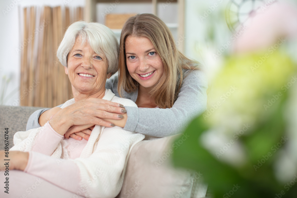 beautiful senior mom and her adult daughter are hugging