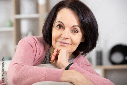 portrait of smiling senior woman relaxing on couch at home