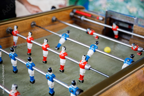 Close-up of kid boy playing table soccer. Happy excited child having fun with family game with siblings or friends. Positive kid.