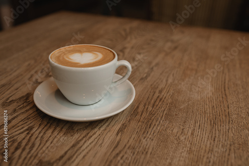 Cup of coffee on wooden table with copy space.