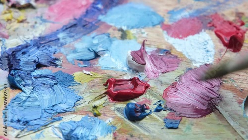 Wallpaper Mural palette with oil colored paints close-up. The artist makes brush strokes, mixes colors Torontodigital.ca