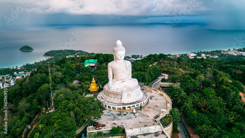 Beautiful Phuket white Big Buddha statue on blue sky background. Aerial view of Big Buddha viewpoint at sunrise in Phuket province, Thailand. © Jitti