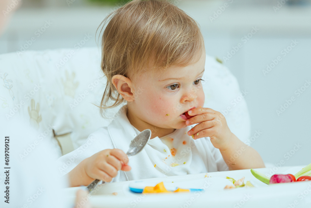 Adorable caucasian toddler girl eats vegetables on her own, pricking them with hands. The concept of self-feeding. BLW. Adorable caucasian toddler girl eats vegetables on her own, pricking them with hands. The concept of self-feeding. BLW.