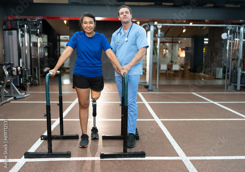 Asia woman walking with prosthetic limb being caucasian assisted physiotherapist