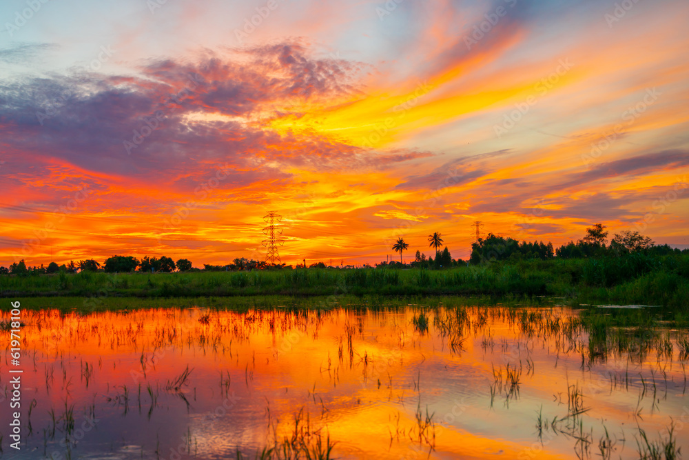 Obraz premium high voltage pole orange sunrise background in the rural fields of Thailand