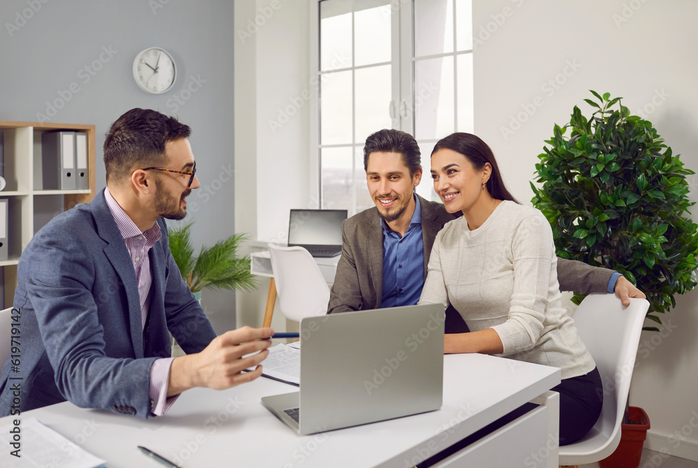 Portrait of happy caucasian couple sitting with a business broker or insurance agent showing project on a laptop screen. Clients having consultation with a man realtor or financial advisor at office. - obrazy, fototapety, plakaty 