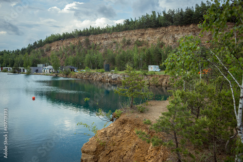 Quarry and crystal clear water in it. Sheer cliffs of the former quarry. Lake with crystal clear water. Panorama of the reservoir from a bird s eye view.