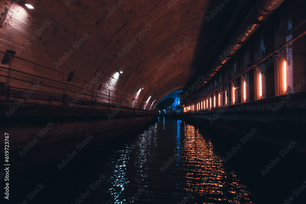 Industrial concrete tunnel perspective with neon lights illumination