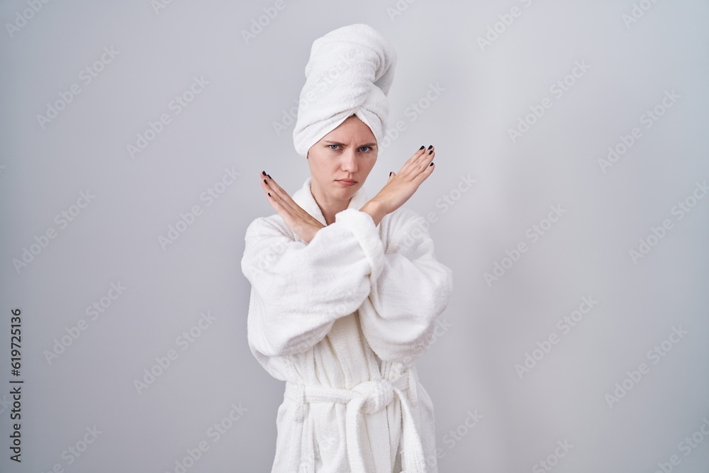 Blonde caucasian woman wearing bathrobe rejection expression crossing arms doing negative sign, angry face Blonde caucasian woman wearing bathrobe rejection expression crossing arms doing negative sign, angry face