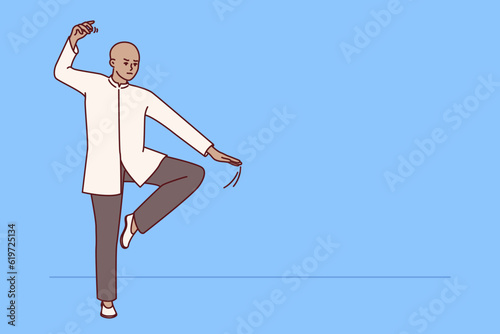 Chinese man practicing qi qong taijiquan does breathing exercises during martial arts training. Specialist in traditional chinese martial gymnastics demonstrates smooth movements for warm-up