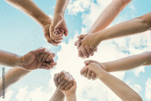 Joined hands as a team. Business teamwork. Close up group of friends meeting join hands together. Diversity people. Partnership volunteer community. Diverse multiethnic Partners. Blue Sky background