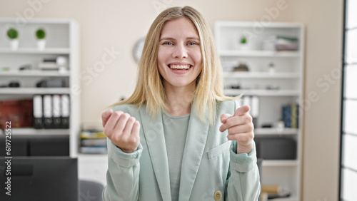 Young blonde woman business worker smiling confident doing come gesture at office