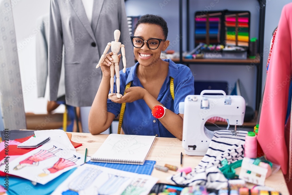 Fototapeta premium African american woman tailor smiling confident holding manikin at tailor shop