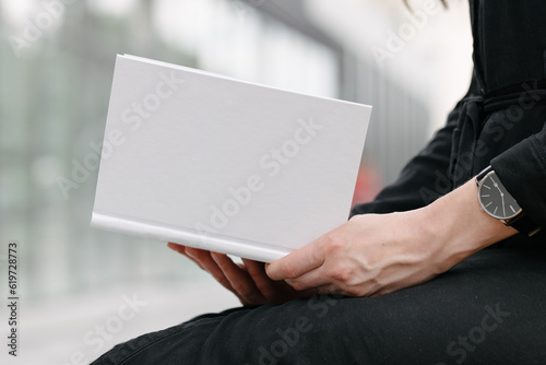 White book cover in woman's hands. Book cover for mock up