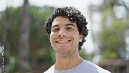 Young latin man smiling confident standing at park