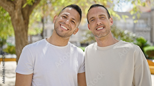 Two men couple smiling confident standing together at park