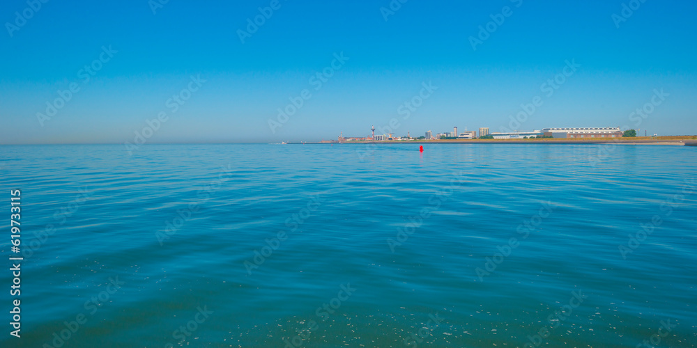 Sand beach along a sea under a dark blue cloudy sky in bright sunlight in summer, Zeeland, the Netherlands, June, 2023 Sand beach along a sea under a dark blue cloudy sky in bright sunlight in summer, Zeeland, the Netherlands, June, 2023