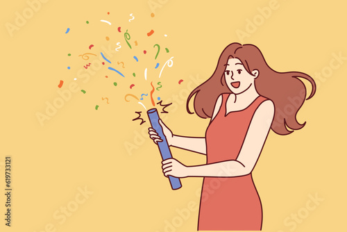 Woman launches confetti during birthday or university graduation party. Girl in beautiful evening dress holds firecracker with confetti, wanting to cheer friends gathered at festive disco