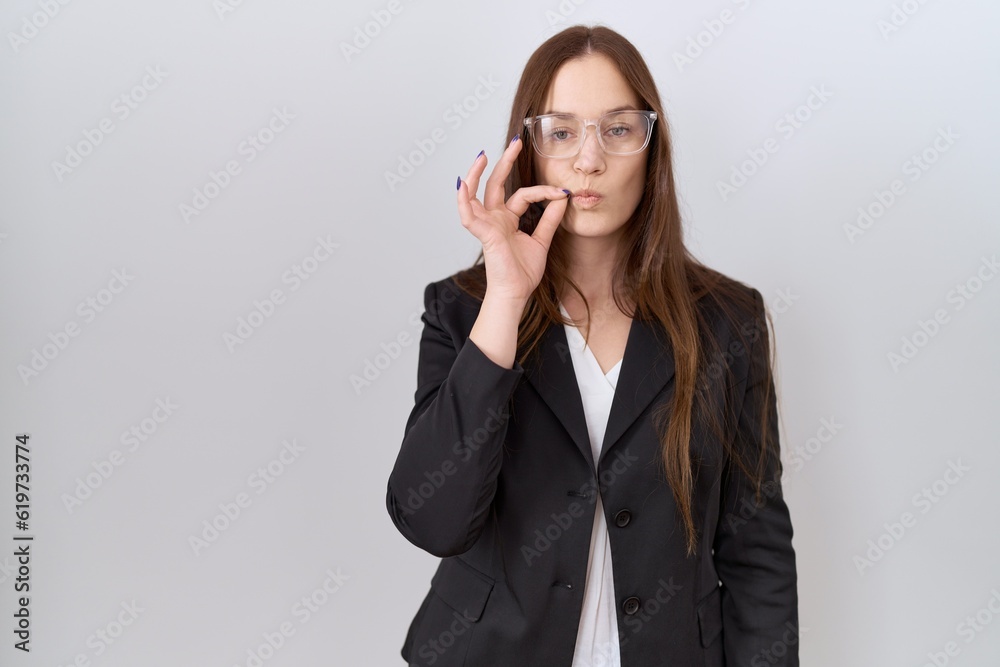 Beautiful brunette woman wearing business jacket and glasses mouth and lips shut as zip with fingers. secret and silent, taboo talking Beautiful brunette woman wearing business jacket and glasses mouth and lips shut as zip with fingers. secret and silent, taboo talking