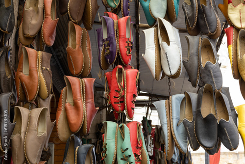Traditional Turkish leather shoes as know yemeni in the Gaziantep traditional market (bazaar). The colorful hand-made leather shoes hanging