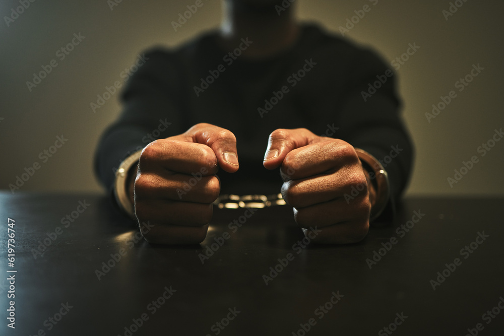 Interrogation, jail and hands of criminal in handcuffs for interview, investigation and arrested in station. Security, law and closeup of man, burglar or thief for crime, stealing and theft in prison - obrazy, fototapety, plakaty 