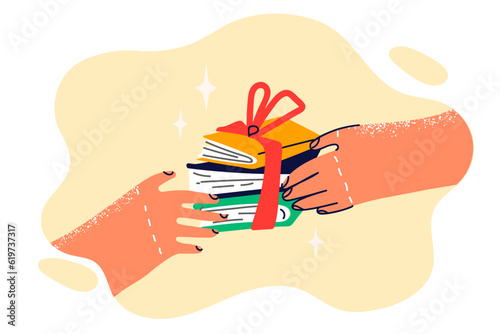 Books with gift ribbon in hands of person symbolize prize to student of school for winning olympiad