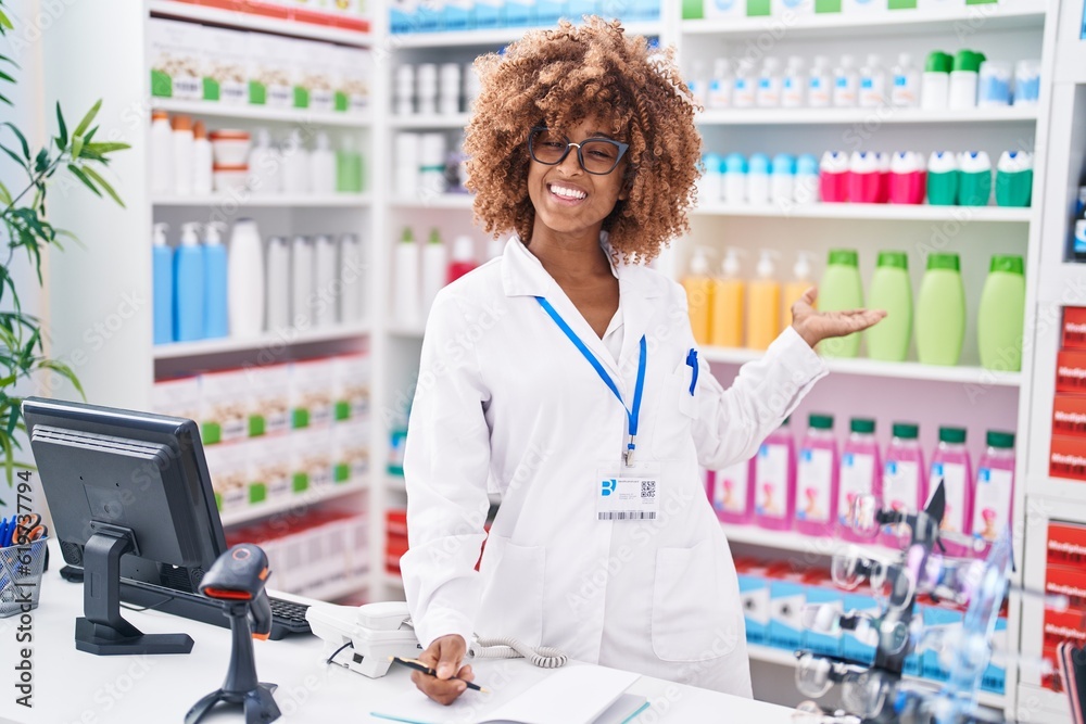 African american woman pharmacist writing on document at pharmacy