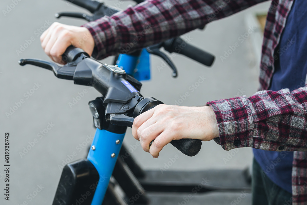 Obraz premium A man using a rental service with an e-scooter, close up.