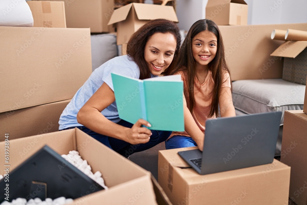 Woman and girl mother and daughter studying at new home Woman and girl mother and daughter studying at new home