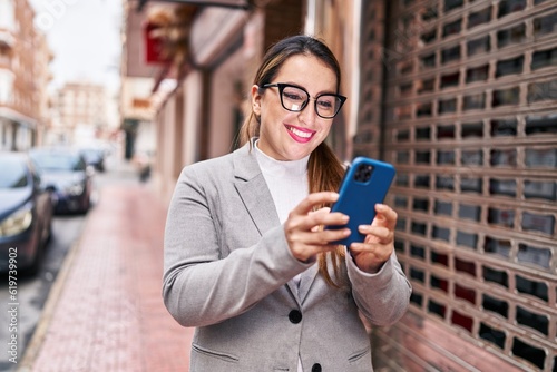 Young beautiful hispanic woman business worker smiling confident using smartphone at street
