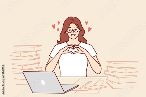 Romantic woman freelancer shows heart with fingers as token of appreciation to clients or employers. Girl in love says hello to boyfriend posing for romantic message at table with papers