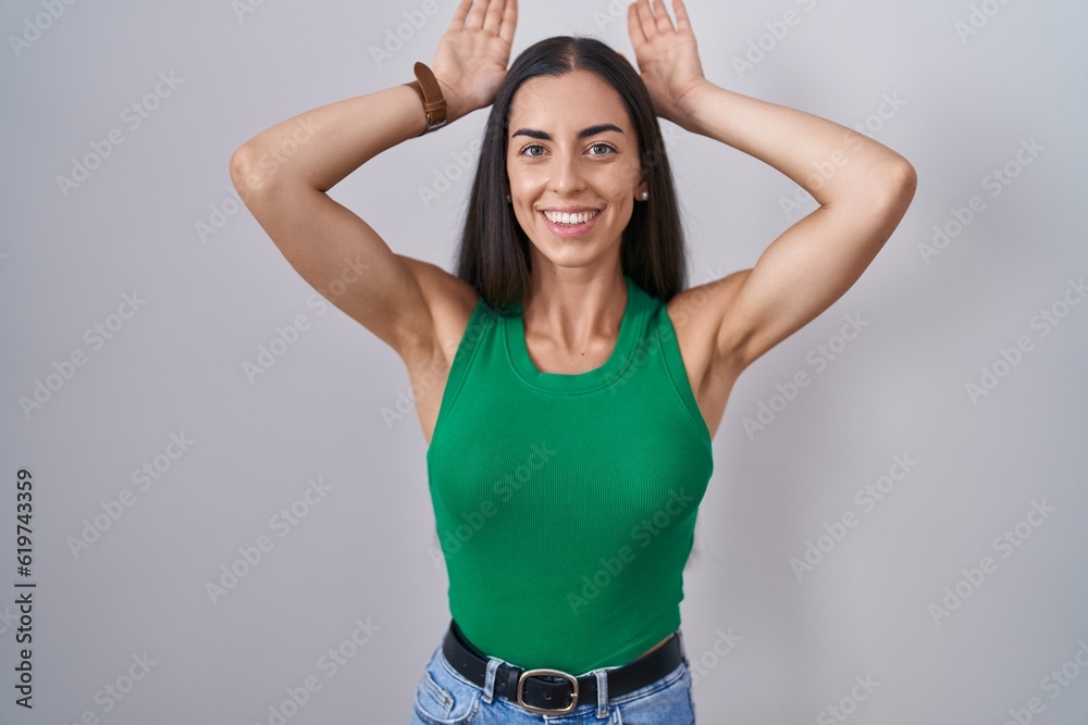 Young woman standing over isolated background doing bunny ears gesture with hands palms looking cynical and skeptical. easter rabbit concept. Young woman standing over isolated background doing bunny ears gesture with hands palms looking cynical and skeptical. easter rabbit concept.