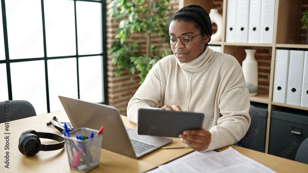 African american woman business worker using touchpad and laptop at office African american woman business worker using touchpad and laptop at office
