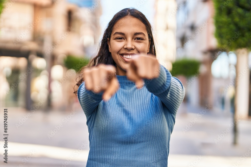 Young african american woman smiling confident pointing with fingers at street
