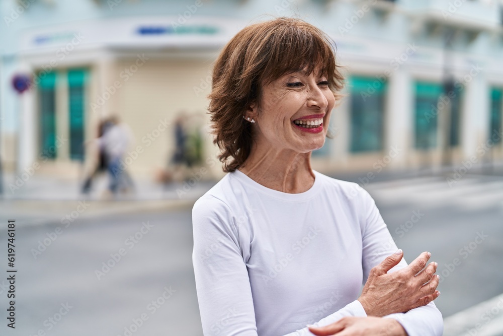 Fototapeta premium Middle age woman standing with arms crossed gesture at street