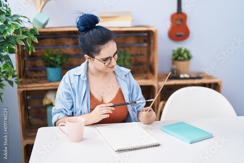 Young caucasian woman smiling confident drawing on notebook at street
