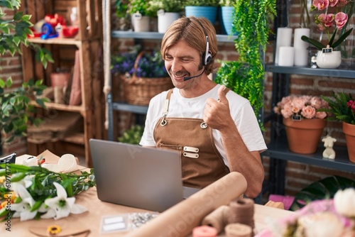 Caucasian man with mustache working at florist shop doing video call smiling happy and positive, thumb up doing excellent and approval sign
