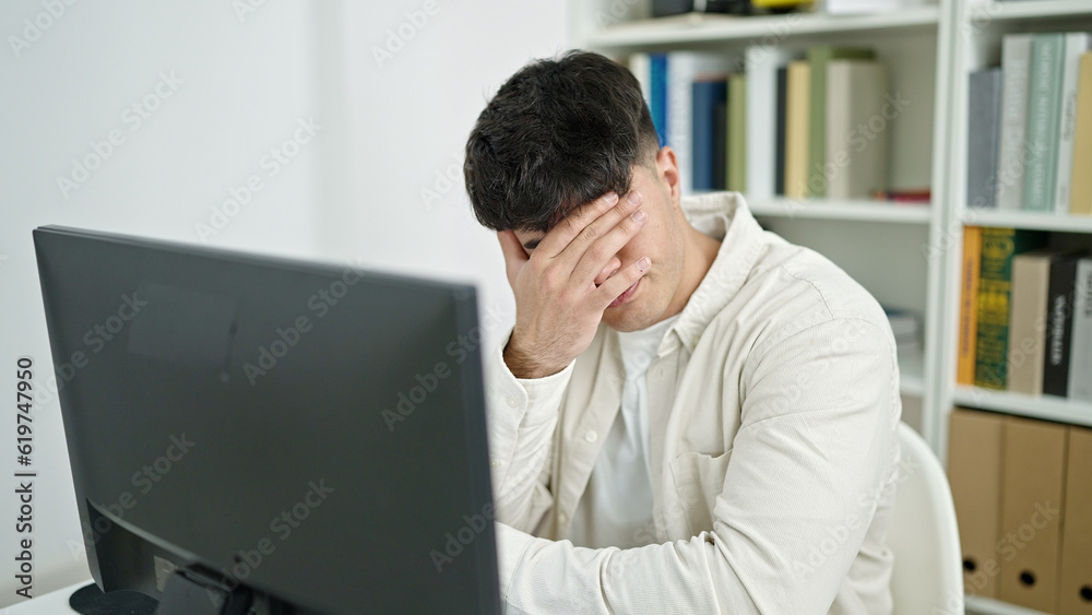 Young hispanic man student stressed using computer studying at library university Young hispanic man student stressed using computer studying at library university
