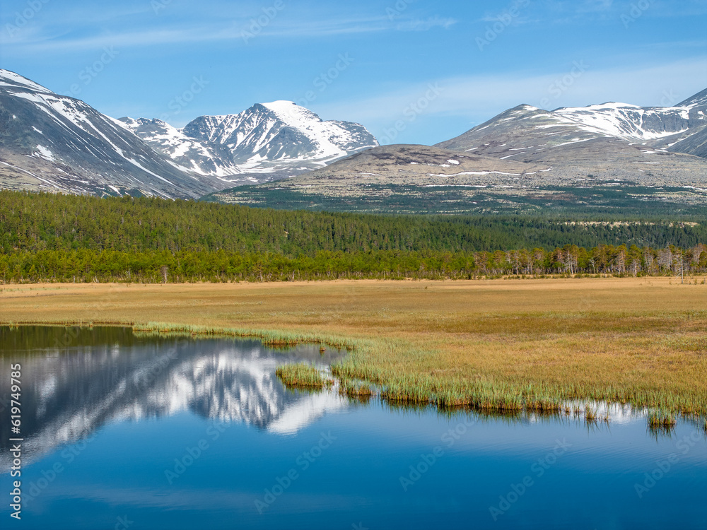 Mountains of Rondane National Park with reflection on a calm lake in Norway
