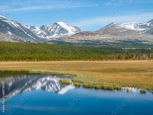 Mountains of Rondane National Park with reflection on a calm lake in Norway