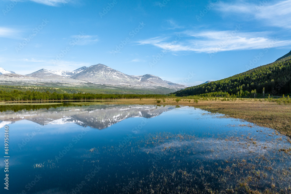 Reflection of mountains on a calm lake in Rondane National Park, Norway