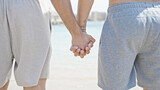 Two men tourist couple standing with hands together at beach