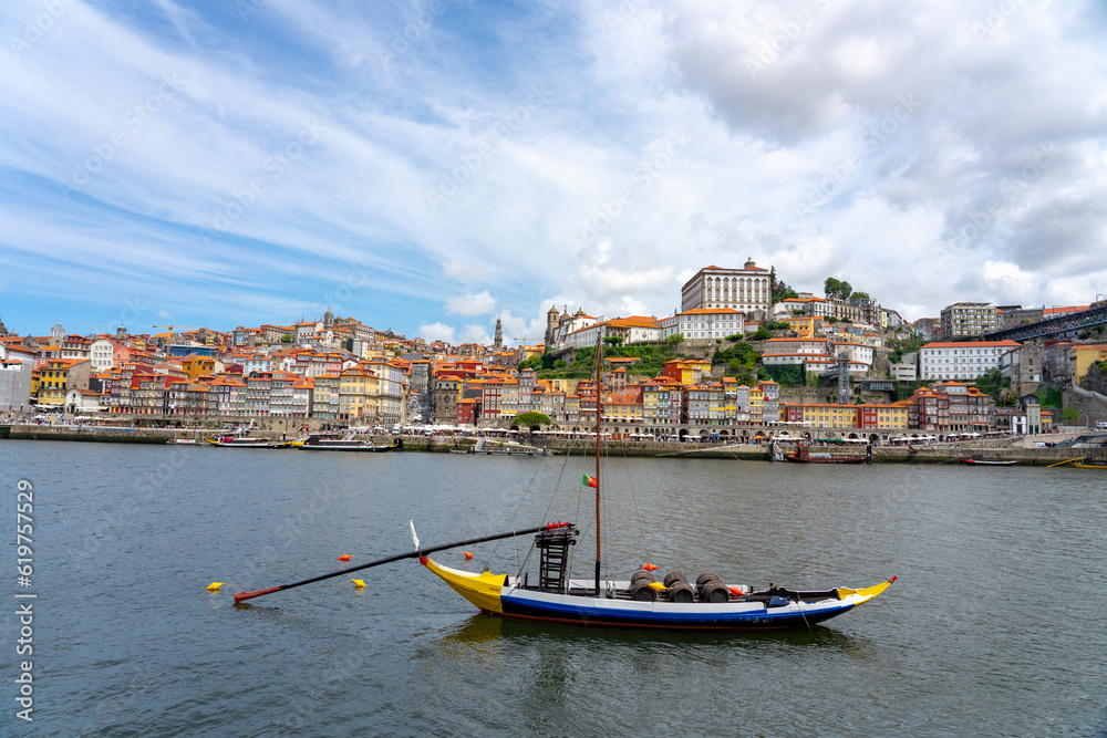 boat with wine barrels with Beautiful colorful building facede background in Porto Portugal next to Duero river in Ribeira