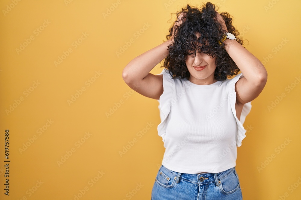 Φωτογραφία Young middle east woman standing over yellow background suffering from headache desperate and stressed because pain and migraine